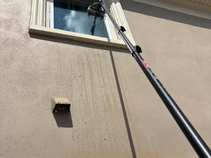 Reaching a second-story window from the ground with a water-fed pole