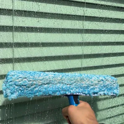 Hand-washing a window with a soapy microfiber applicator